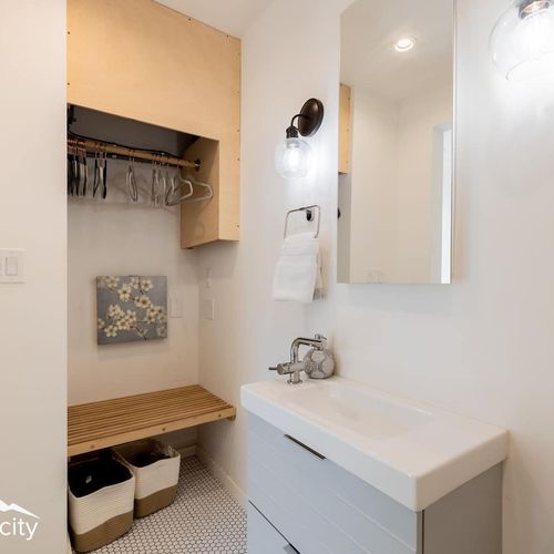 - get ready with ease at a well lit vanity featuring fresh towels and essentials
- unpack into an open closet with hangers, bench space, and storage baskets
- practical touches and thoughtful layout make this a stress free space to settle in