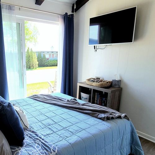 Bedroom #1:  bedroom #1 features a queen-size bed, private entrance, a great view of crystal lake, a ceiling fan, matching nightstands with lamp, a closet, and its own television.