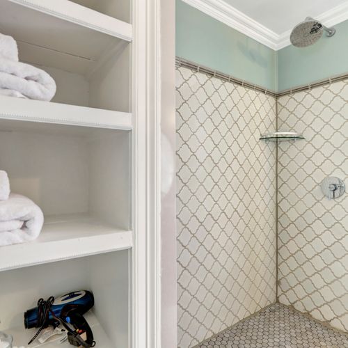 Walk-in shower with rainfall head and fresh, premium towels for your comfort.