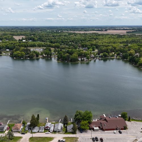 Exterior:  a drone shot of the house with the lake in the background