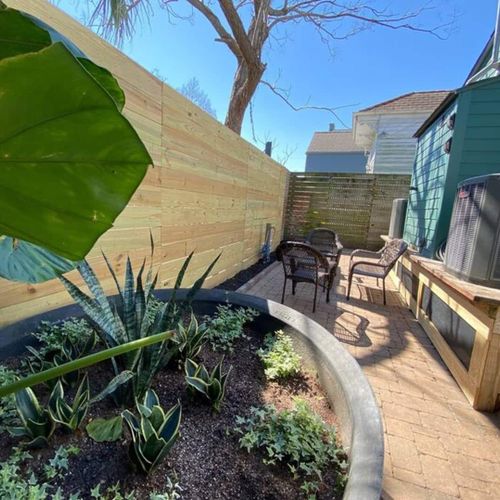 Lush front yard w/ mature plants & a welcoming, colorful exterior.