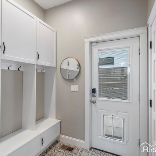 The entryway features a spacious mudroom with coat hooks, ample storage, and a convenient bench, making it easy to keep your home organized and welcoming.