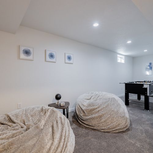 The downstairs game room includes a foosball table, extra large bean bag chairs, and tons of board games!