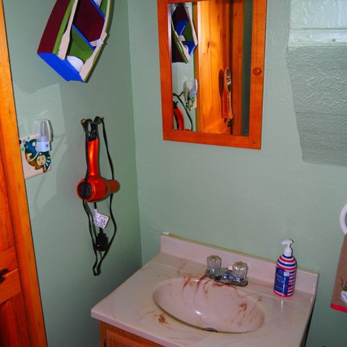 Bathroom:  very cute little bathroom with a sink, vanity, mirror, toilet, shower, and chair.