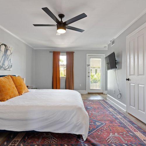 Cozy bedroom w/ ceiling fan & warm decor for a relaxing stay.