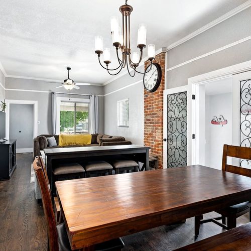 - combined dining and living space is made for entertaining and relaxing in style
- brick accents and black metal details add vintage flair to the modern layout
- natural light and soft finishes make every corner feel inviting and bright