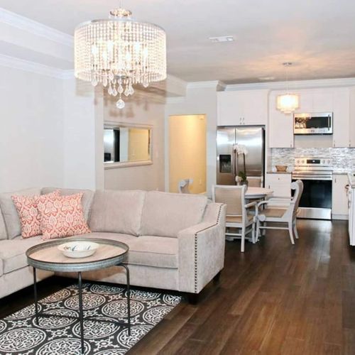 Open-concept living, dining & kitchen area bathed in warm light.
