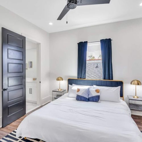 Upstairs king bedroom w/ en-suite bath, warm wood tones & cozy layered linens.