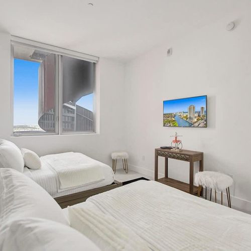 Bedroom 2 features two full-size beds and a private TV, making it perfect for children or guests on a family vacation.