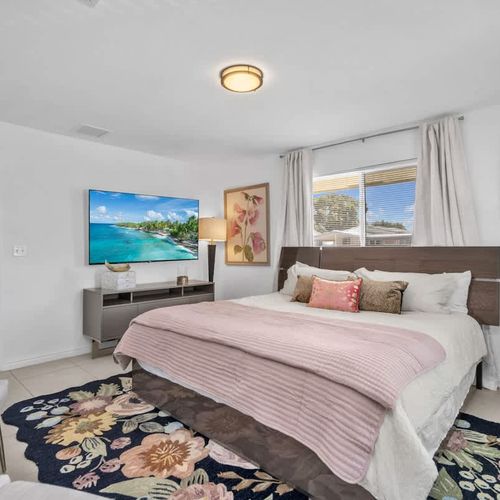 The unit features spacious bedrooms, each furnished with plush beds, crisp linens, and a private TV for ultimate comfort.