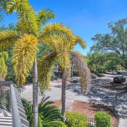 Enjoy a tropical vibe from your private balcony, surrounded by lush palm trees and a peaceful neighborhood view.