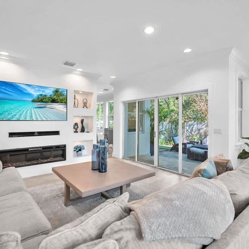 A bright and inviting living space with a cozy sectional, stylish décor, and a large TV for entertainment. The open layout flows seamlessly to the outdoor patio, creating the perfect spot to relax and unwind.