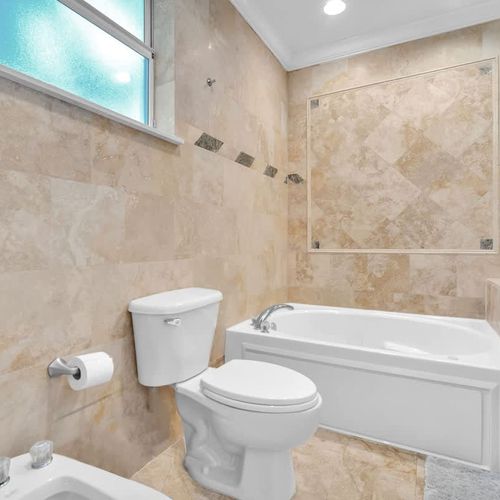 Luxurious bath with elegant tile, a soaking tub, and a bright, relaxing vibe.