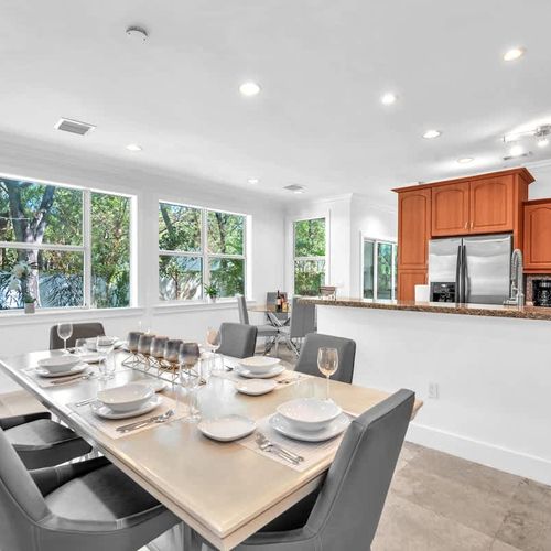 Enjoy meals in this bright dining space with large windows and an open layout connecting to the kitchen. A perfect spot for gathering, whether for a casual breakfast or a special dinner.