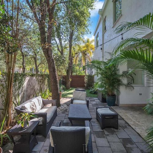 Tranquil outdoor lounge with lush greenery, cozy seating, and a serene vibe—ideal for relaxing or entertaining.