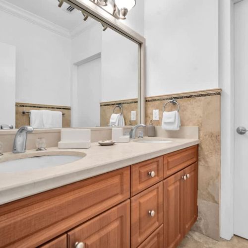 Elegant bathroom with a spacious vanity, double sinks, and warm wood accents. A perfect space to refresh and unwind.