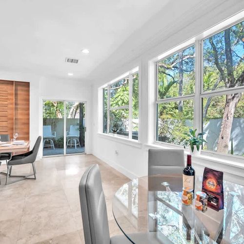 Bright and inviting dining space with large windows showcasing lush greenery. Enjoy meals indoors or step outside to the cozy patio for fresh air and relaxation.