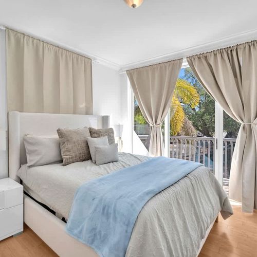 Wake up to natural light in this cozy, stylish bedroom 2 and floor-to-ceiling windows leading to a private balcony with peaceful views.