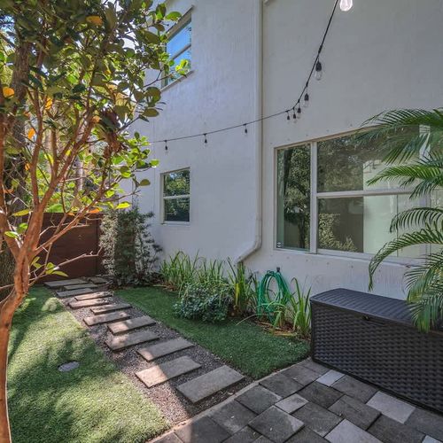 Charming garden pathway with lush greenery, string lights, and a cozy ambiance—perfect for a peaceful retreat