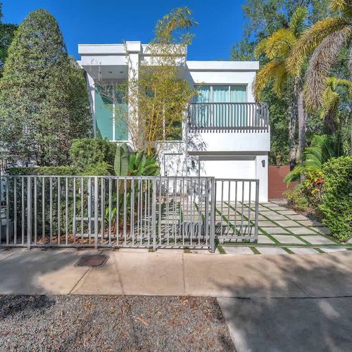Modern gated home with lush greenery and sleek design. Enjoy a stylish stay with private balconies and an inviting outdoor space.