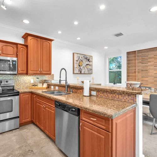 A spacious kitchen with modern appliances and plenty of counter space, perfect for preparing meals with ease. The open layout flows into the dining area, making it great for entertaining or casual dining.