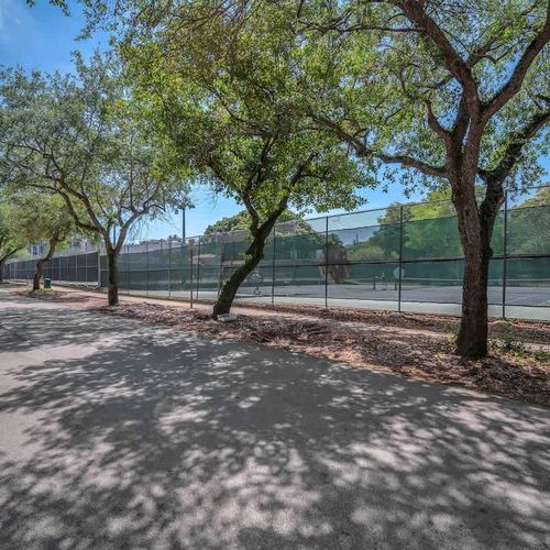 Tree-lined street with nearby tennis courts—perfect for a morning match or a scenic walk.