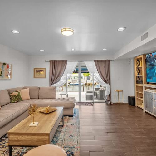 Soak in the laid-back vibes of this cozy living room that opens right out to a breezy patio with a stunning waterfront view—perfect for morning coffee or sunset unwinding.