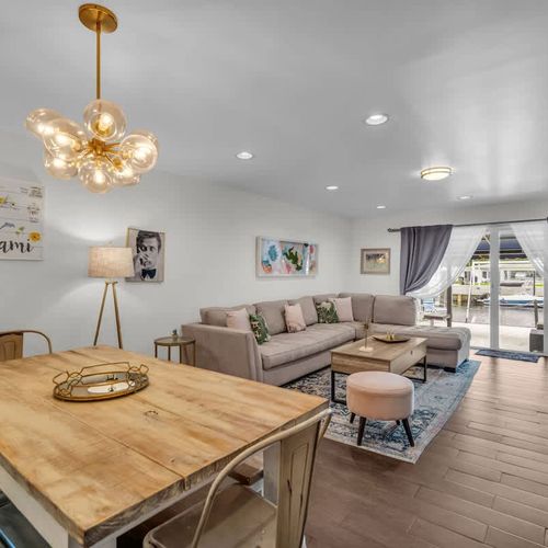 Feel right at home in this open-concept living and dining space, where cozy comfort meets modern flair. Gather around the rustic table for meals or unwind on the plush sectional under chic lighting—all just steps from your private patio escape.