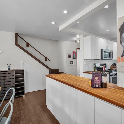 Step into style with this eclectic and inviting space, where bold art meets modern charm. The open layout flows from kitchen to dining, making it perfect for sharing meals, music, and memories.