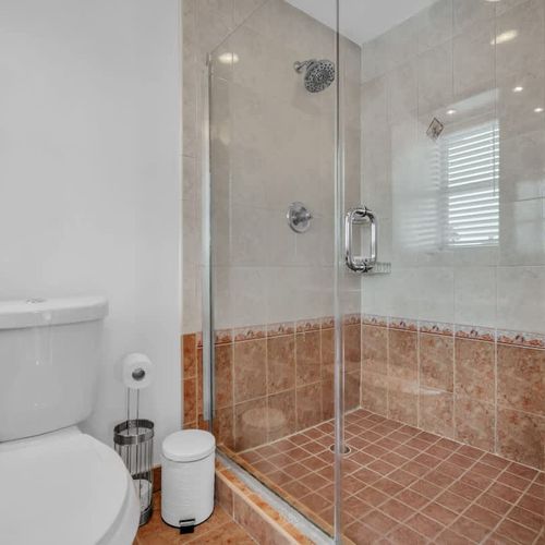 Relax in the full bathroom featuring a roomy walk-in shower and all the essentials for a refreshing stay.