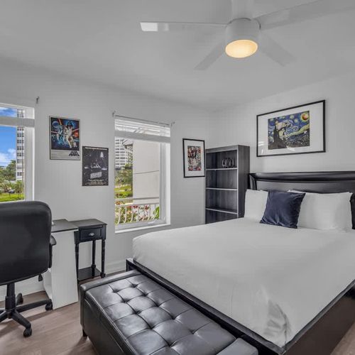 Recharge in this sleek, sunlit bedroom featuring a plush queen bed, dedicated workspace, and artistic touches. With city views and a calming vibe, it’s the perfect spot to relax, work, or dream in style.