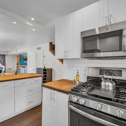 Elevate your stay with a modern stainless steel gas range—complete with four burners and a center griddle, ideal for pancakes, grilled sandwiches, or sautéing.