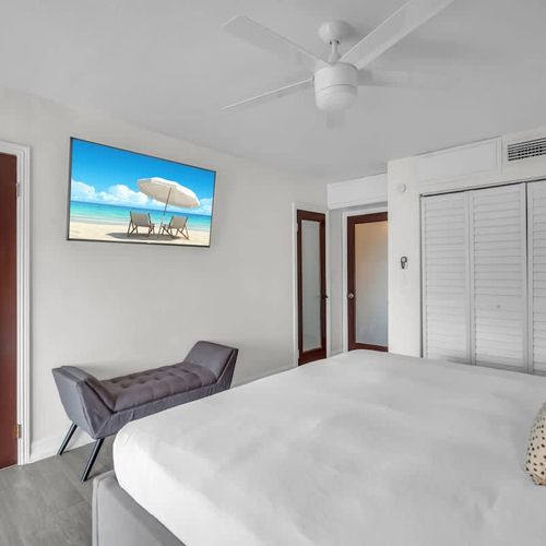 Primary bedroom featuring a spacious walk-in closet, a comfy king bed, and a TV for laid-back vacation nights.