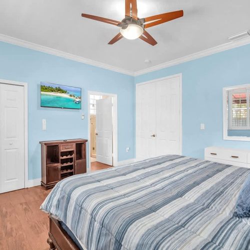 Spacious and serene first bedroom, complete with its own en suite bathroom and a TV for your entertainment.
