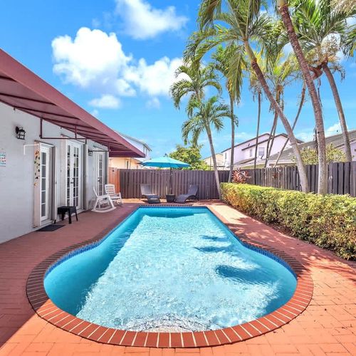 Enjoy sunny days by the private pool, surrounded by lush greenery, cozy umbrellas, and a charming patio.