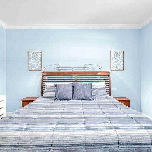Spacious and serene first bedroom, complete with its own en suite bathroom and a TV for your entertainment.