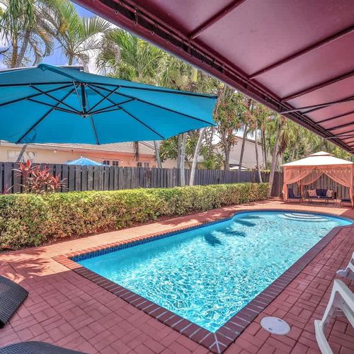 Enjoy sunny days by the private pool, surrounded by lush greenery, cozy umbrellas, and a charming patio.