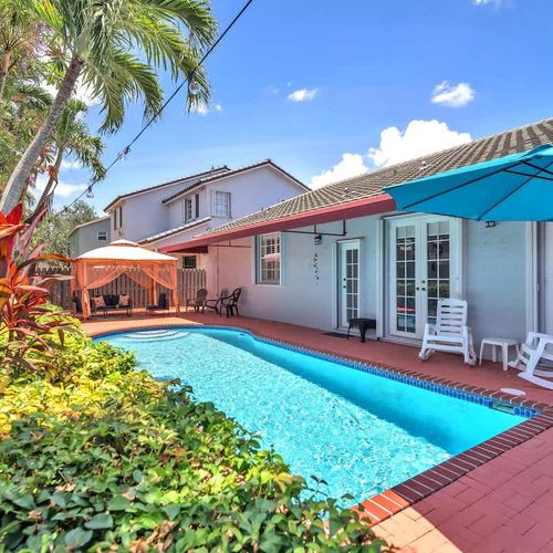 Enjoy sunny days by the private pool, surrounded by lush greenery, cozy umbrellas, and a charming patio.