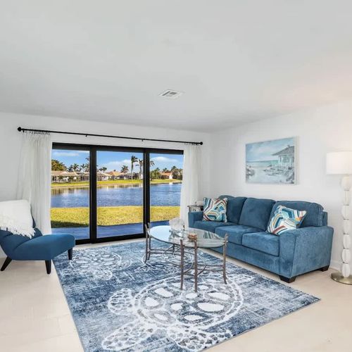 Bright and cozy living space with a comfortable couch and a large sliding glass door overlooking the lake.