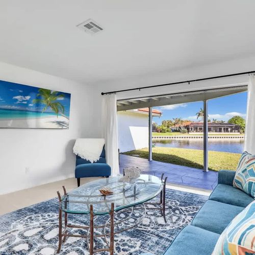 Bright and cozy living space with a comfortable couch and a large sliding glass door overlooking the lake.