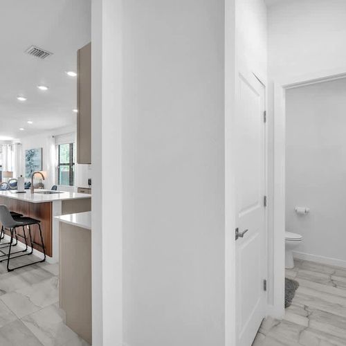 The sleek, newly updated kitchen offers generous cupboard space and a roomy island meal prep or casual dining.