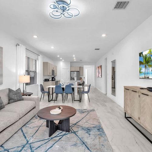Relax in the bright and airy living room featuring a plush, inviting couch, tasteful décor, and a big screen for your favorite films and series.
