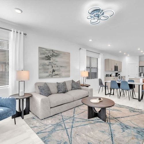 Relax in the bright and airy living room featuring a plush, inviting couch, tasteful décor, and a big screen for your favorite films and series.