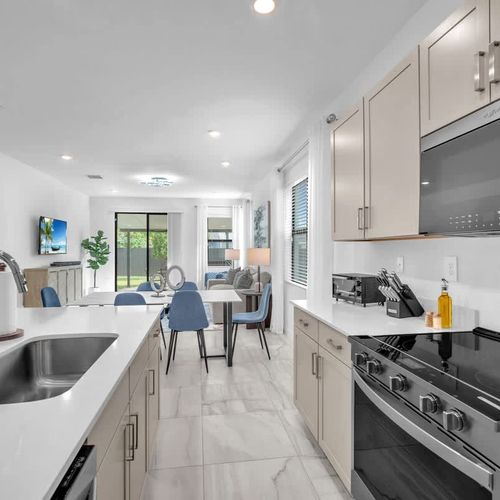 The sleek, newly updated kitchen offers generous cupboard space and a roomy island meal prep or casual dining.