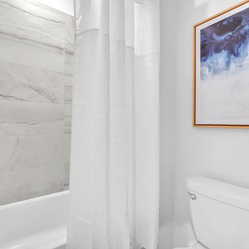 Bathroom 2 combines cleanliness and comfort, featuring a roomy vanity and a dedicated bathtub.