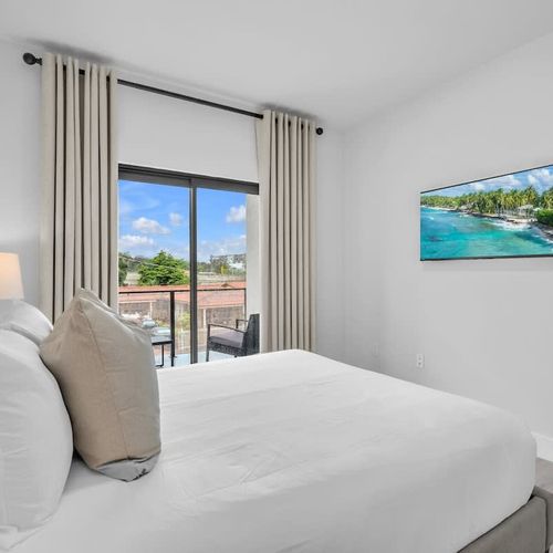 Bedroom 2 features a cozy queen-sized bed and direct access to the balcony—perfect for enjoying fresh air and morning coffee.