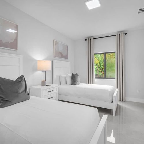 Bedroom 4 offers two cozy single beds, a private TV, generous closet space, and an ensuite bathroom—an excellent choice for kids or families needing extra room and comfort.