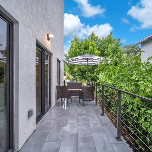 Spacious balcony with outdoor seating—great for coffee, reading, or simply relaxing after a day out in South Florida.