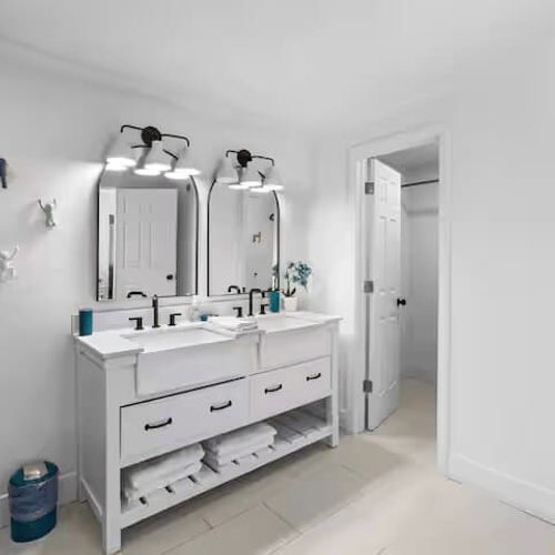 The bathroom is thoughtfully designed with his-and-hers mirrors, plenty of storage cabinets, and a spacious closet, offering both comfort and convenience for an extended stay or a relaxing getaway.