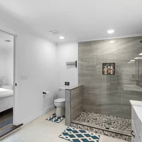 Mid century modern bathroom with natural light, terrazzo floors and marble on the walls and shower.